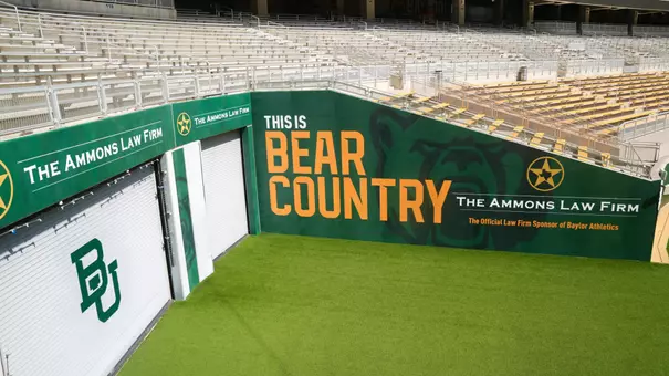 New Baylor Athletics tunnel wall wraps at McLane Stadium featuring The Ammons Law Firm branding alongside a "This Is Bear Country" graphic and Baylor Bear imagery