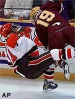 Forward Jeff Farkas levels St. Lawrence center Charlie Daniels during the first period of their NCAA Division I semifinal game in Providence, R.I., Thursday.
