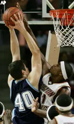 Center Sean Williams blocks a shot by Maine's Olli Ahvenniemi during the first half.