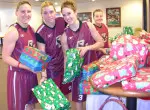 Members of the women's basketball team wrapped holiday presents for the two children they adopted.