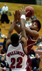 Sean Williams gets a shot off over defender Bryant McAllister of Duquesne University.