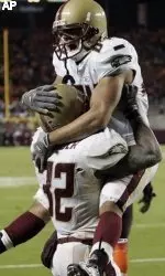 Boston College running back Andre Callender (32) lifts teammate Kevin Challenger as they celebrate the winning touchdown. (AP Photo/Steve Helber)