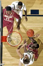 Boston College forward Corey Raji (11) and Michigan guard Manny Harris, top, watch as Boston College guard Biko Paris, right, shoots over Michigan guard Zack Novak, bottom. (AP)