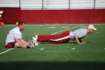 Mark Herzlich performs a pushup while senior captain Mike McLaughlin stretches before Sunday afternoon's practice in Alumni Stadium.