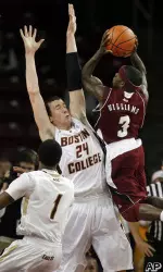 Boston College's Dennis Clifford (24) defends against Massachusetts' Chaz Williams (3).