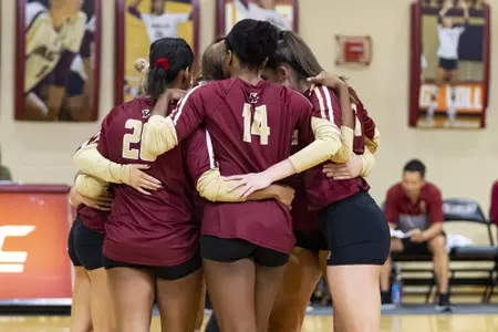 The volleyball team huddles before a match in Power Gym