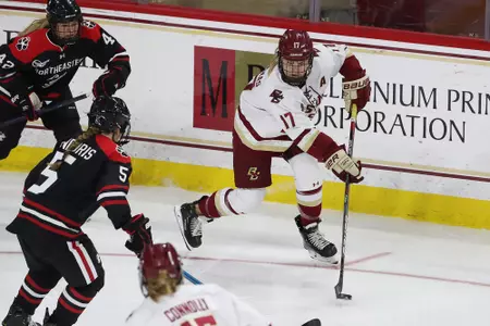 Delaney Belinskas battles for the puck along the boards against Northeastern.