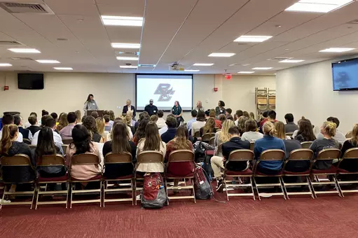 Current Eagle seniors listen to alums speak about job hunting.