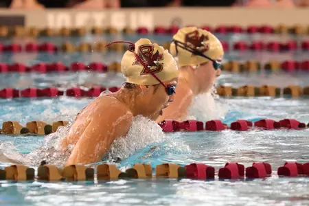 The women's swim team races at the Connell Center