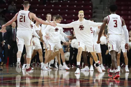 BC men's basketball players celebrate heading into a timeout