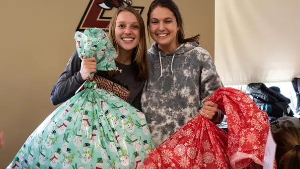 Women's soccer players at the 2019 Adopt-A-Child event with their wrapped gifts