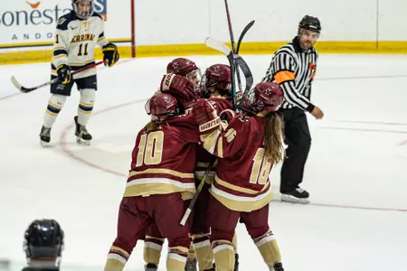 WOmens hockey players celebrate a goal against Merrimack.