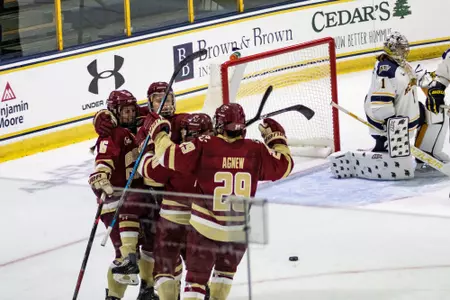 Players celebrate a goal against Merrimack.