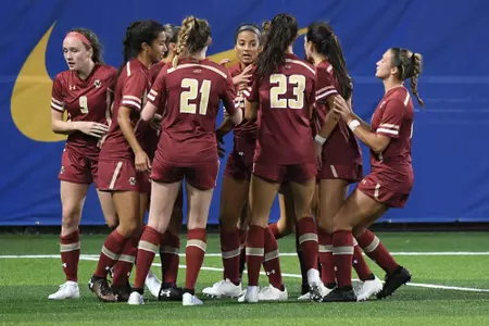 The women's soccer team celebrates a goal.