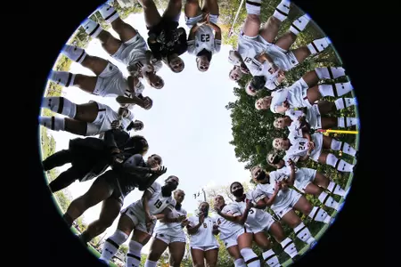 The women's soccer team huddles before a game.