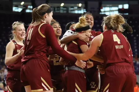 The team smothers Makayla Dickens after the win over Clemson, 2.9.20