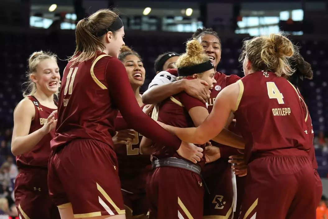 The team smothers Makayla Dickens after the win over Clemson, 2.9.20