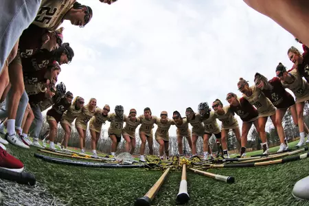 The lacrosse team huddles before taking on Brown