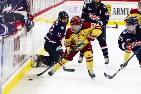 Cayla Barnes plays the puck along the boards against UConn.