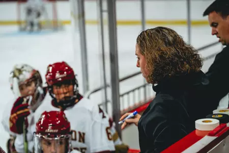 Women's hockey associate head coach Courtney Kennedy on the bench.