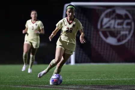 Sarai Costello dribbles the ball up the field.