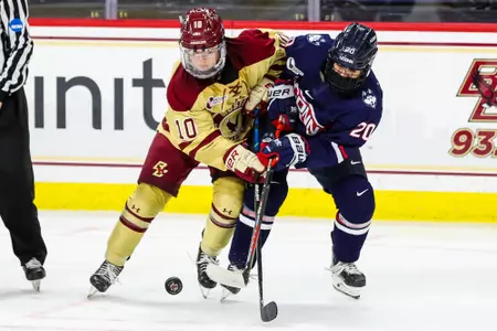 Carolie DiFiore battles for the puck against a UConn Husky.