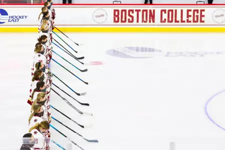 The Boston College women's hockey team stands on the blue line during the national anthem.