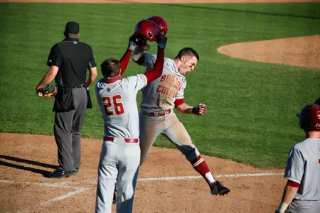 Sal Frelick and Dante Baldelli tap helmets following Frelick's game-tying home run at Auburn.