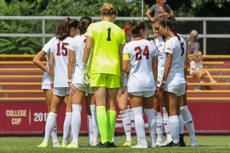 The women's soccer team huddles before kick off.
