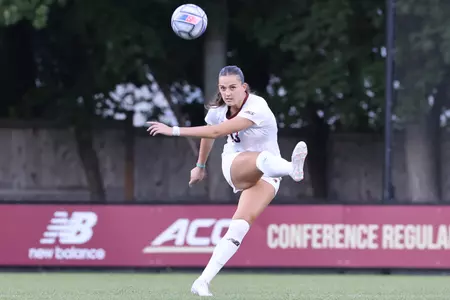 Claire Mensi kicks the ball up the field against Syracuse.