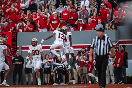 Zay Flowers is met in the end zone by Dino Tomlin to celebrate his first touchdown at NC State.