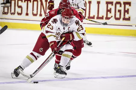Cayla Barnes drives over the blue line against a Harvard defender.