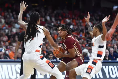 Boston College guard DeMarr Langford Jr., center, is defended by Syracuse forward Maliq Brown, left, and guard Judah Mintz during the first half of an NCAA college basketball game in Syracuse, N.Y., Saturday, Dec. 31, 2022. (AP Photo/Adrian Kraus)