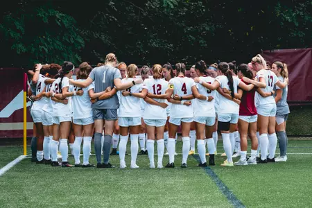 The women's soccer team huddles before kick off.