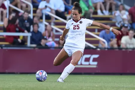 Sophia Lowenberg plants her left leg and looks to kick the ball with her right foot.