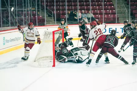 Cayla Barnes lifts her stick to celebrate Gaby Roy's goal just as she scores.