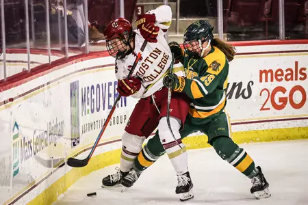 Abby Newhook battles for the puck along the boards against Vermont.