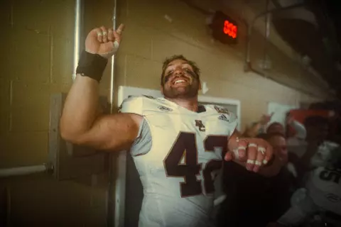 Vinny DePalma leads the signing of "For Boston" in the locker room at Army.
