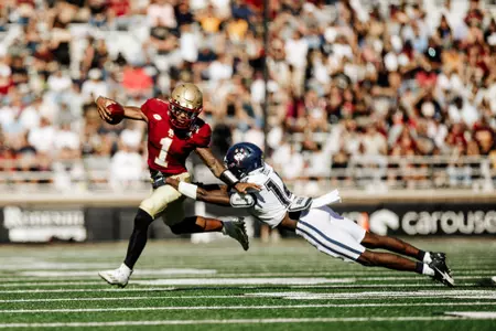 Thomas Castellanos breaks the tackle of a Huskies defender