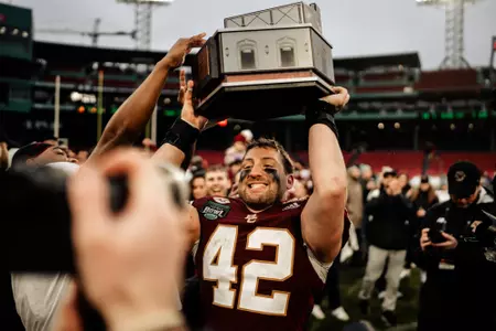 Vinny DePalma hoists the Fenway Bowl trophy after a 23-14 win over SMU.