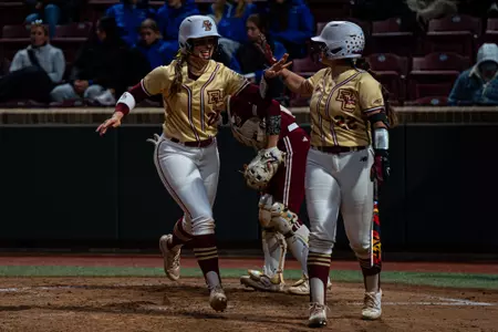 Meg Schouten and Hannah Slike celebrate during game against UMass
