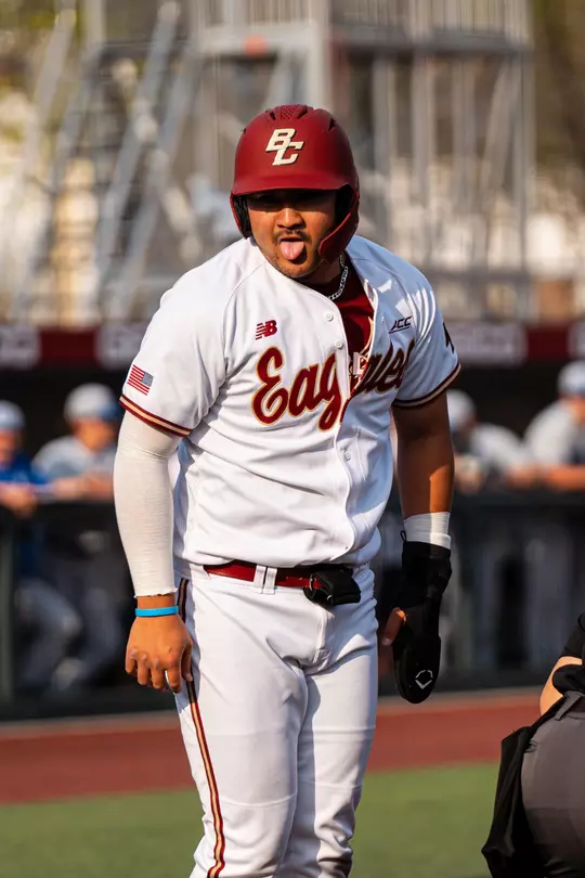 Nick Wang sticks his tongue out to the dugout after scoring a run.