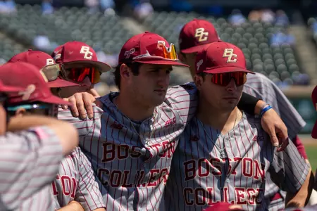 Joe Vetrano and Daniel Baruch with arms over each other's shoulders during the pregame hitter's meeting.