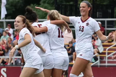The BC women's soccer team celebrates a goal.