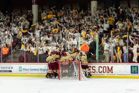 BC players celebrate behind the net in front of a packed student section.