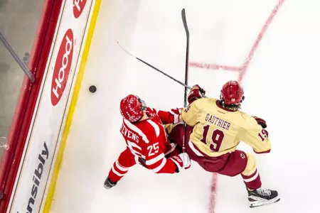 Cutter Gauthier battles for the puck along the boards.