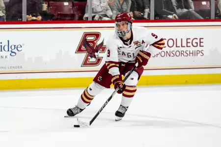 Ryan Leonard skating with puck against AIC