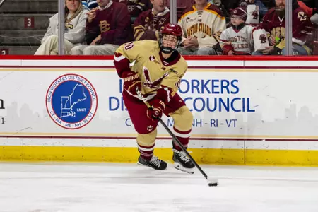 James Hagens skating with puck against Maine