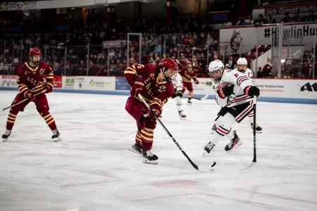 Oskar Jellvik protecting puck against Northeastern