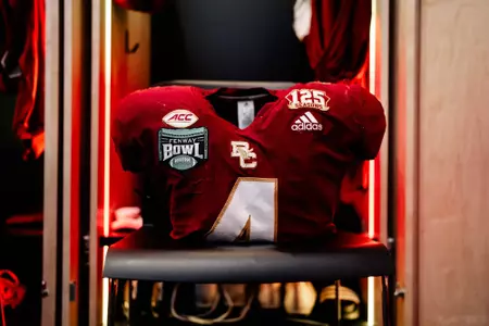 BC jersey No. 4 with Fenway Bowl patch rests on a locker room stool.